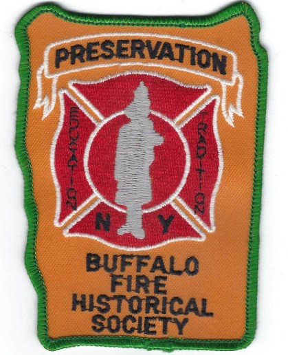 This is a patch with a green thread border and an orange background. At the top, in a white-outlined banner graphic, is the word "Preservation." In the middle is a red fire emblem, bisected by a grey silhouette of a firefighter. On either side are the words "education" and "tradition" in vertical black lettering. On either side of the silhouette's feet are the letters "N" and "Y." At the bottom are the words "Buffalo Fire Historical Society' in black.